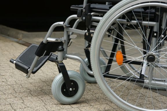 Silla de ruedas con un diseño moderno y ruedas grandes en una superficie de piedra.